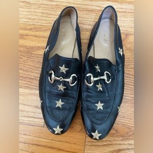 Black leather slip on loafer with gold stars and buckle